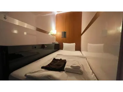 a bed in a room with a robe on it at First Cabin Ichigaya 