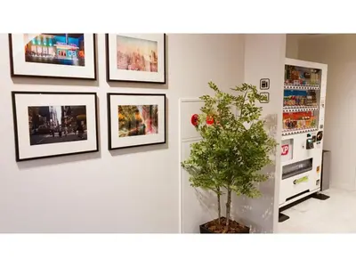 a room with pictures on the wall and a plant at First Cabin Ichigaya 