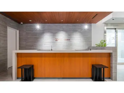 a lobby with a bar with two stools at First Cabin Ichigaya 
