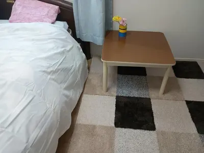 a small table next to a bed and a table with flowers at N's room & park ,Tokyo, Guest House - Vacation STAY 18814 in Tokyo