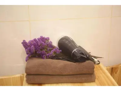 a hair dryer sitting on a pile of towels with purple flowers at MIYAVI hotel - Vacation STAY 75579v in Tokyo