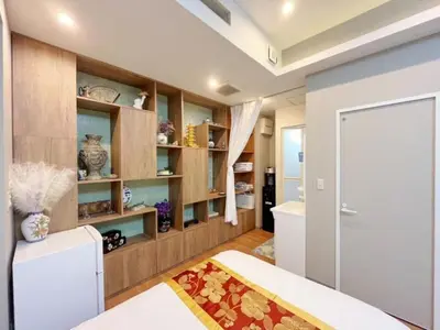 a kitchen with a white refrigerator and wooden shelves at MIYAVI hotel - Vacation STAY 75522v in Tokyo