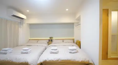 two beds in a room with towels on them at Yuina Hotel Shinjuku in Tokyo