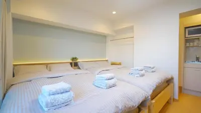 two beds in a room with towels on them at Yuina Hotel Shinjuku in Tokyo