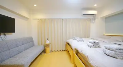 a hotel room with two beds and a couch at Yuina Hotel Shinjuku in Tokyo