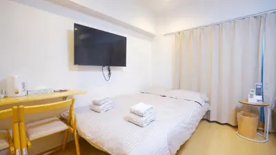 a small room with a bed with towels on it at Yuina Hotel Shinjuku in Tokyo
