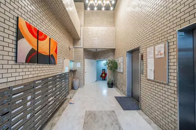 a hallway in a building with a painting on the wall at Yuina Hotel Shinjuku in Tokyo