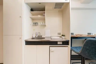 a small kitchen with white cabinets and a sink at Frt\u6c60\u888b2\u4e01\u76ee906 in Tokyo