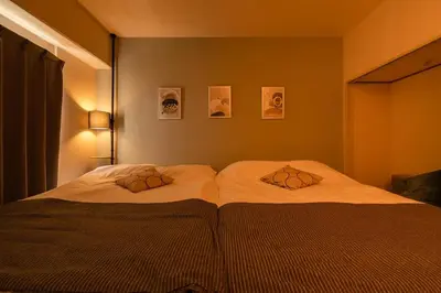 a bedroom with two beds and two pictures on the wall at Frt\u6c60\u888b2\u4e01\u76ee906 in Tokyo