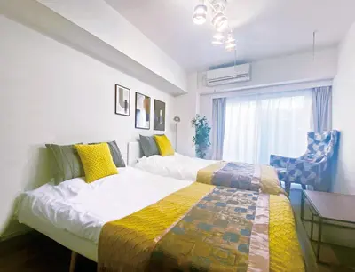a bedroom with two beds and a table and a chair at #17 -\u30b7\u30fc\u30d5\u30a9\u30eb\u30e0\u4eac\u6025\u84b2\u7530- Entire Unit in Tokyo