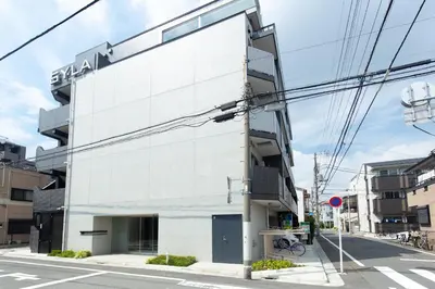 a white building with a sign on the side of it at #17 -\u30b7\u30fc\u30d5\u30a9\u30eb\u30e0\u4eac\u6025\u84b2\u7530- Entire Unit in Tokyo