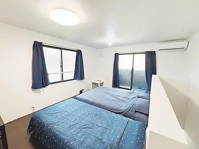 a bedroom with a blue bed and two windows at Tokyo Stay Top Ikebukuro #203 in Tokyo