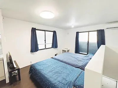a bedroom with a blue bed and two windows at Tokyo Stay Top Ikebukuro #203 in Tokyo