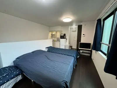 a bedroom with two beds and a refrigerator in it at Tokyo Stay Top Ikebukuro #203 in Tokyo