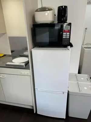 a microwave on top of a refrigerator in a kitchen at Tokyo Stay Top Ikebukuro #203 in Tokyo