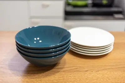 a blue bowl sitting next to a stack of plates at Y's INN Nakano 016T in Tokyo