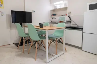 a kitchen with a table with chairs and a television at Y's INN Nakano 016T in Tokyo