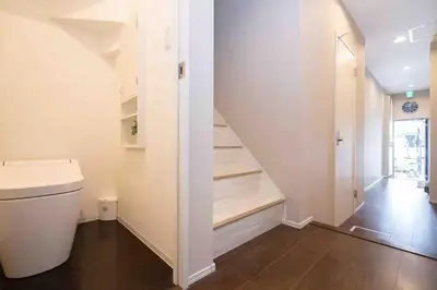 a bathroom with a toilet and stairs in a house at W Haus \u6771\u4eac\u6674\u7a7a\u5854\u8def\u7a0b3\u5206 \u6d45\u8349\u5bfa\u8def\u7a0b10\u5206 \u8d85\u5927\u7a7a\u95f4\u72ec\u680b\u522b\u5885 \u6700\u591a11\u4f4d\u5165\u4f4f in Tokyo