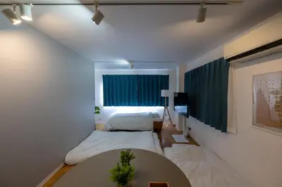 a bedroom with two beds and a table and a window at FINOA Asakusa Sky Terrace in Tokyo
