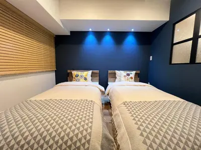 two beds in a room with blue walls at Kameido Wisteria Retreat 3 Floor in Tokyo