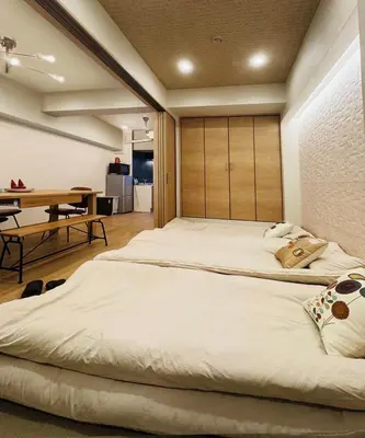 a bedroom with a large bed and a table at Kameido Wisteria Retreat 3 Floor in Tokyo