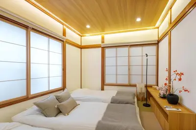 a bedroom with two beds and a desk and windows at MINE HOME\u6771\u4e2d\u91ce 116t in Tokyo