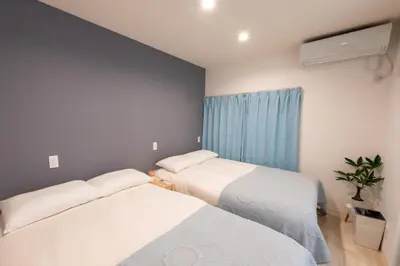 two beds in a small room with a window at Y's INN アネックス 012T in Tokyo