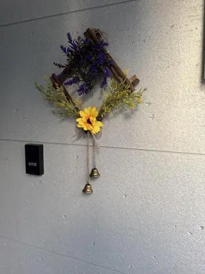 a flower wreath on a wall with a bell at rd\u6c11\u6cca2F in Tokyo
