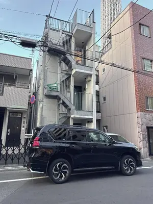 a black car parked in front of a building at rd\u6c11\u6cca2F in Tokyo