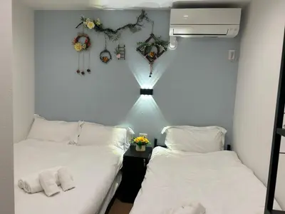 a room with two beds and a light between them at rd\u6c11\u6cca3F in Tokyo