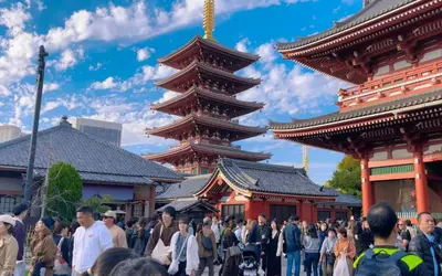 a crowd of people walking in front of two pagodas at rd\u6c11\u6cca3F in Tokyo