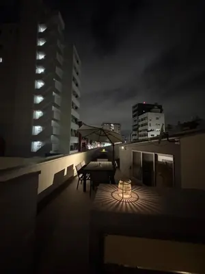 a rooftop patio at night with a table and chairs at DesignAward,Alphinaud in Tokyo