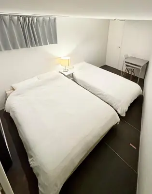 two beds in a room with white sheets at DesignAward,Alphinaud in Tokyo