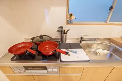 a kitchen counter with two pots and pans on a stove at MINE HOME\u6771\u6c60\u888b 117t in Tokyo