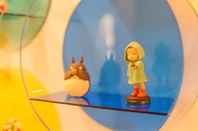 a glass shelf with a figurine of a person and a chicken at MINE HOME\u6771\u6c60\u888b 117t in Tokyo