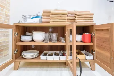 a wooden cabinet with plates and dishes on it at Y's INN NishiShinjuku 018T in Tokyo