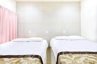 two beds in a room with white walls at Y's INN NishiShinjuku 018T in Tokyo
