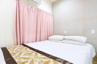 a bedroom with a bed with a pink curtain at Y's INN NishiShinjuku 018T in Tokyo