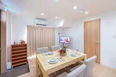 a dining room with a wooden table and chairs at Y's INN Ikefukuro 109T in Tokyo
