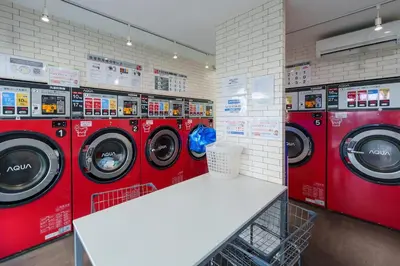 a laundry room with red washing machines in a store at Y's INN Ikefukuro 109T in Tokyo