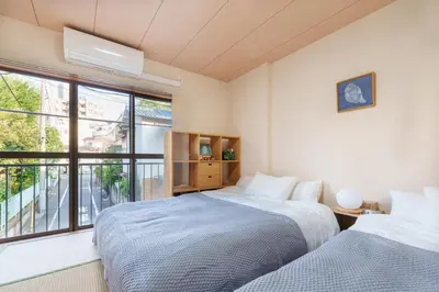 two beds in a room with a window at Y's INN Ikefukuro 109T in Tokyo