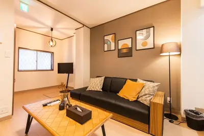 a living room with a black couch and a table at \u697d\u5bbf Itabashi 011T in Tokyo