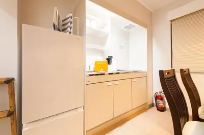 a kitchen with a white refrigerator in a room at \u697d\u5bbf Itabashi 011T in Tokyo