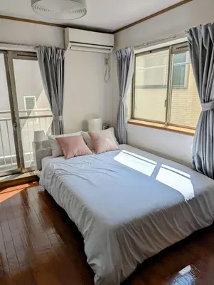 a large bed in a room with windows at Nomado Base at YOYOGI in Tokyo