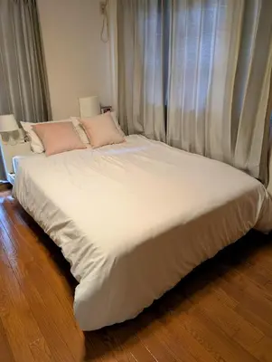 a large bed with white sheets and pink pillows at Nomado Base at YOYOGI in Tokyo