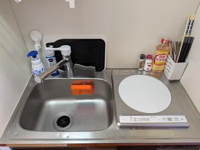 a kitchen counter with a sink and a mirror at Nomado Base at YOYOGI in Tokyo
