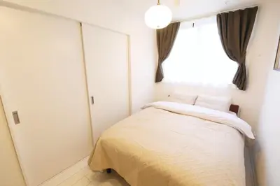 a small bedroom with a bed and a window at ALDO INN Toyosu in Tokyo