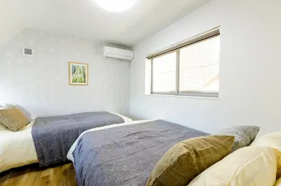 two beds in a bedroom with a window at \u697d\u5bbf Nishi Shinjuku 017T in Tokyo