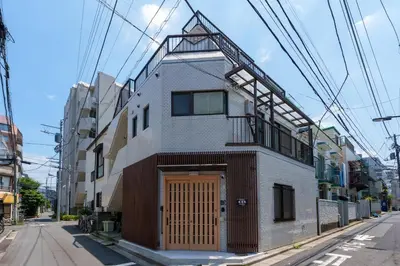 a building with a wooden door on a street at \u697d\u9038\u30b0\u30eb\u30fc\u30d7 \u6c60\u888b\u745e\u6708\u82d11F 111Ta in Tokyo
