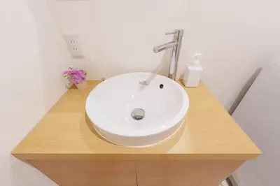 a white sink in a bathroom with a wooden counter at \u697d\u9038\u30b0\u30eb\u30fc\u30d7 \u6c60\u888b\u745e\u6708\u82d11F 111Ta in Tokyo